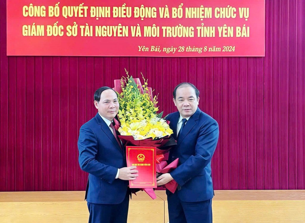 Ông Tạ Văn Long - Phó Bí thư Thường trực Tỉnh ủy, Chủ tịch HĐND tỉnh Yên Bái trao quyết định và tặng hoa ông Trần Ngọc Luận - Giám đốc Sở TN&MT tỉnh.