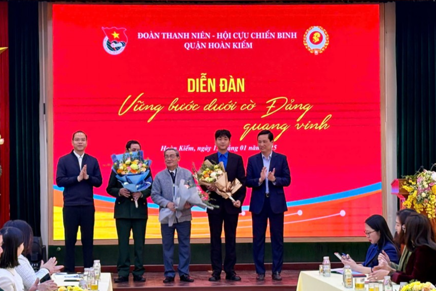 Phó Bí thư Thành đoàn, Chủ tịch Hội Sinh viên thành phố Hà Nội Nguyễn Tiến Hưng; Phó Bí thư Thường trực Quận ủy Hoàn Kiếm Nguyễn Quốc Khánh tặng hoa khách mời tham dự diễn đàn 